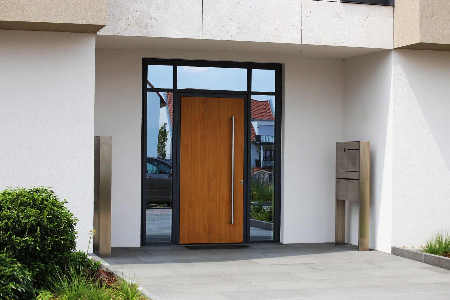 Moderner Haustüren aus Aluminium mit einem Holzdekor und zwei Seitenteilen und einem Oberlicht