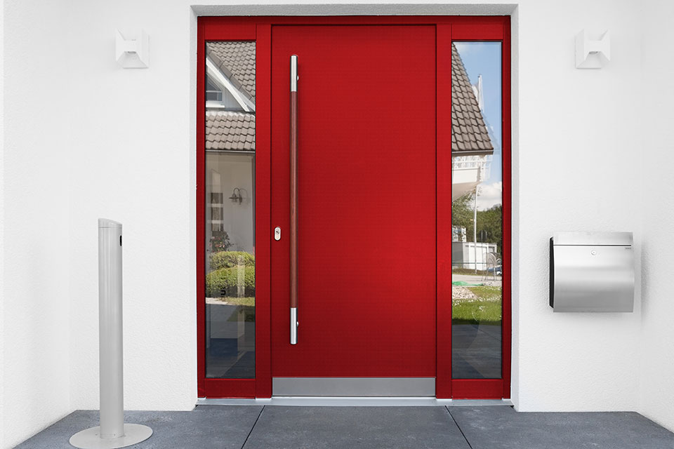 rote Haustüre mit zwei Seitenteilen und einem langen Stangengriff