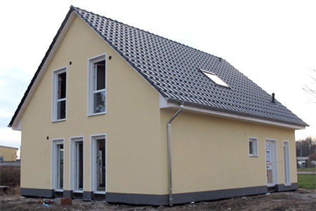 gelbes Einfamilienhaus mit weißen Fenstern