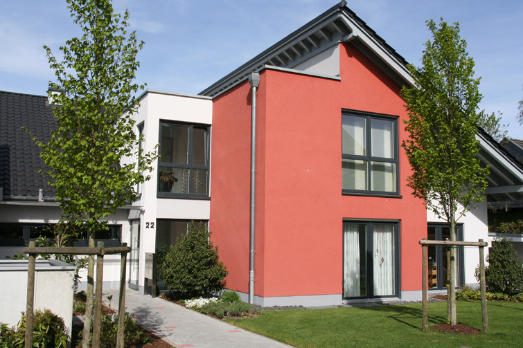rote Hausfassade mit modernen Fenstern 