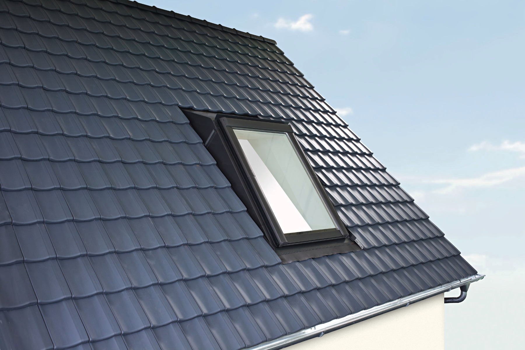 Graues Dachflächenfenster auf einem Dach montiert, Ansicht von Außen