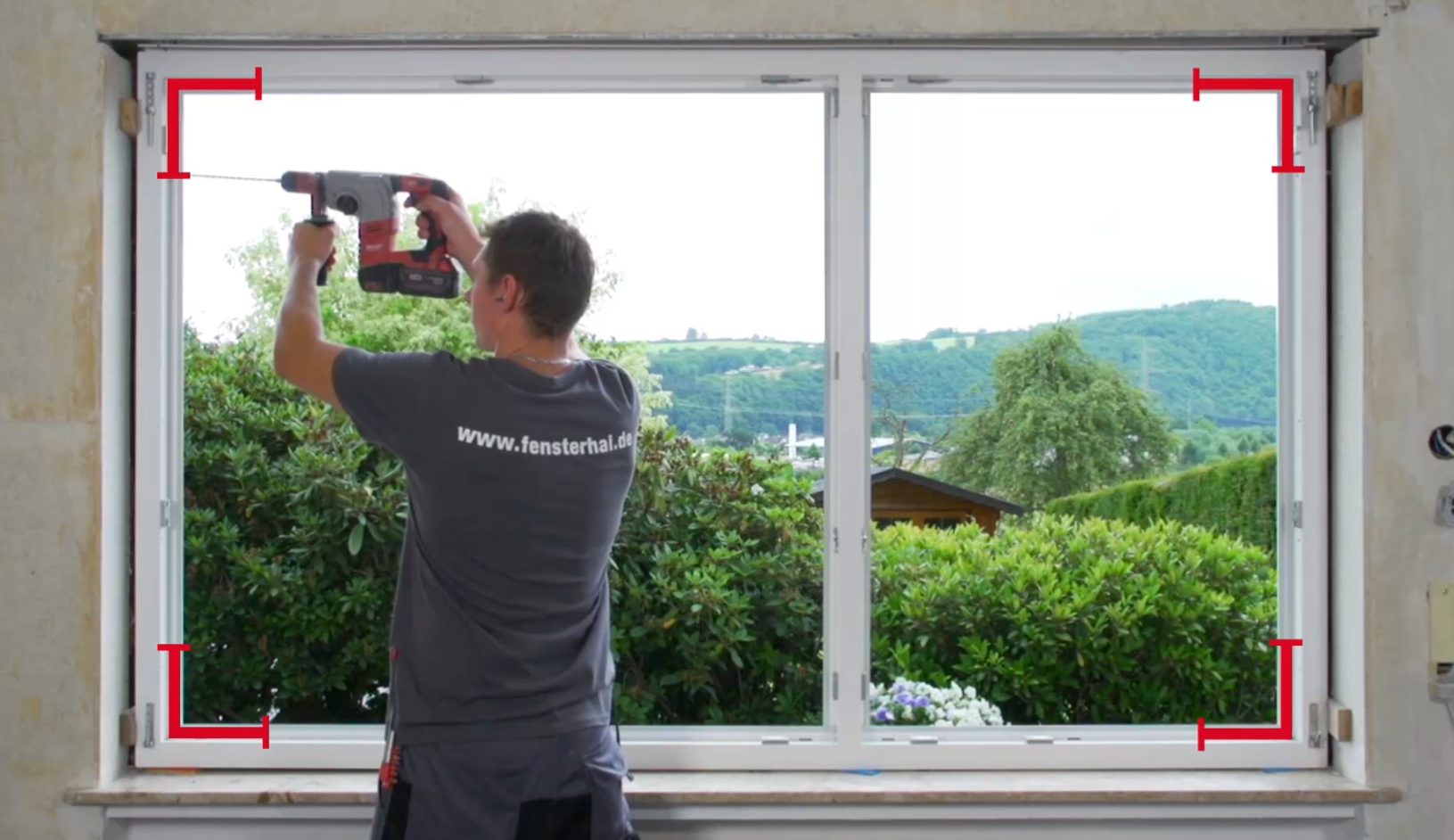 Fenstermonteur setzt die Wandbohrungen für den Fenstereinbau